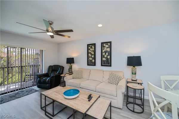 a living room with furniture a rug a window and a flat screen tv