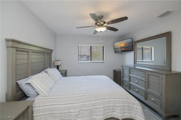 a bedroom with a large bed and a chandelier