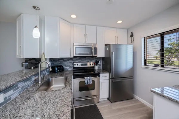 a kitchen with a refrigerator sink and microwave