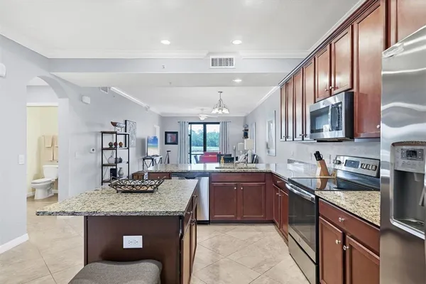 a kitchen with stainless steel appliances kitchen island granite countertop a sink stove and cabinets