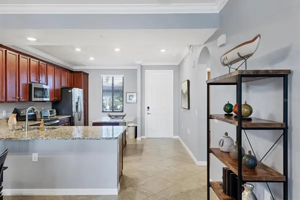 a kitchen with stainless steel appliances granite countertop a sink stove refrigerator and microwave