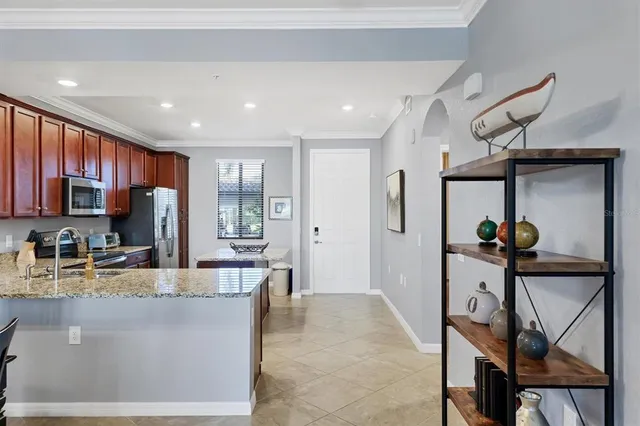 a kitchen with stainless steel appliances granite countertop a sink stove refrigerator and microwave