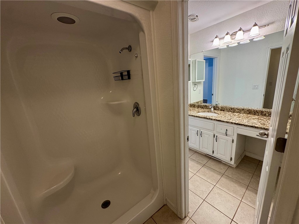 1197 Ridgeview Lane Russellville, AR 72802 - Photo 26 of 44 Bright bathroom featuring a white vanity with a patterned countertop, a built-in mirror, and a four-light fixture