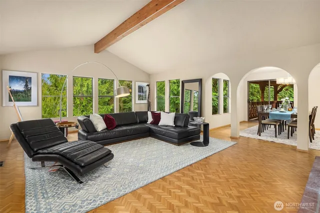 a living room with furniture and large windows with wooden floor