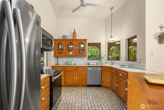 a kitchen with stainless steel appliances granite countertop a stove a sink and a refrigerator