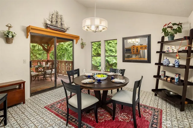 a view of a dining room with furniture a rug and wooden floor