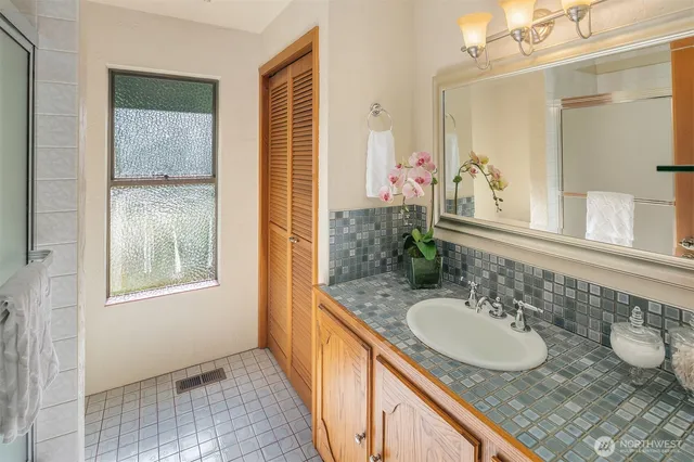 a bathroom with a granite countertop sink and a mirror