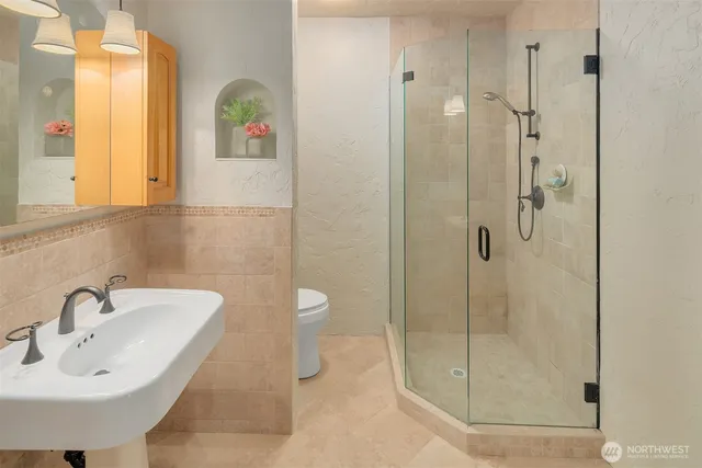 a bathroom with a sink a toilet and shower