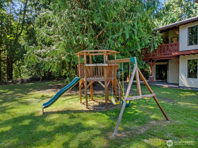 a view of a house with a yard and trees