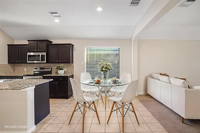 a kitchen with stainless steel appliances kitchen island granite countertop a sink and a stove top oven with wooden floor