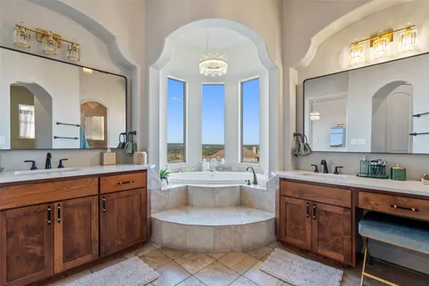 a spacious bathroom with a double vanity sink a mirror and a bathtub