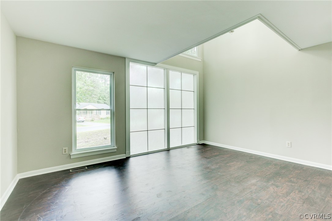 15820 Tri Gate Road Chester, VA 23831 - Photo 6 of 29 an empty room with wooden floor and windows with curtains
