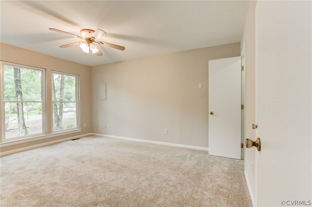 15820 Tri Gate Road Chester, VA 23831 - Photo 8 of 29 an empty room with chandelier fan and windows