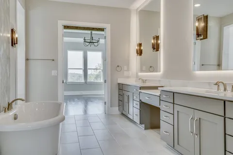 a bathroom with a tub a sink and mirror