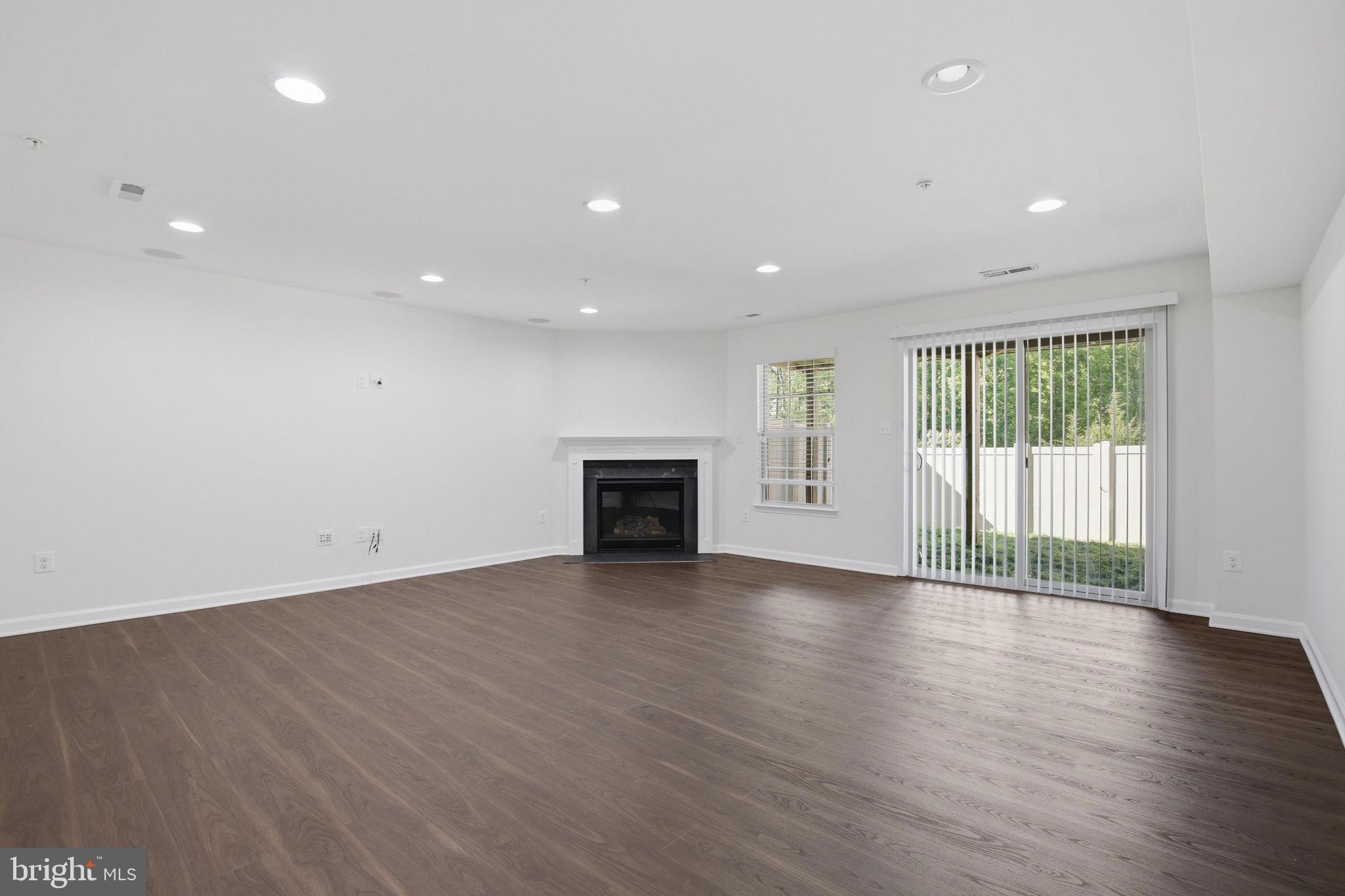 2784 Fredericksburg Road Hanover, MD 21076 - Photo 9 of 60 an empty room with wooden floor and fireplace