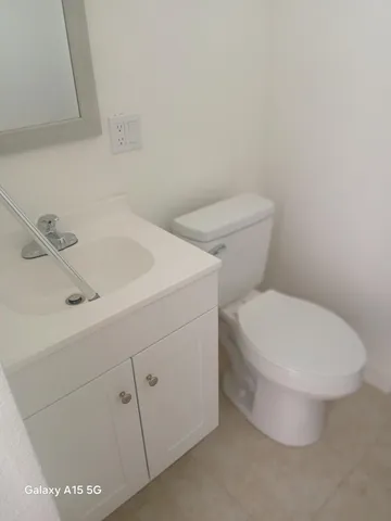 a white toilet sitting next to a bathroom sink