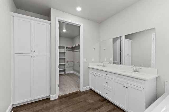 a spacious bathroom with a double vanity sink a mirror and a bathtub