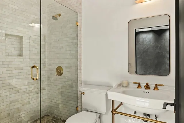 a bathroom with a toilet a sink and mirror