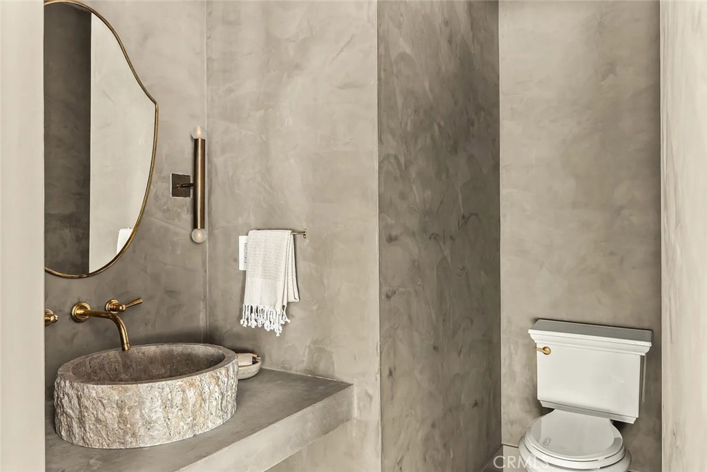 738 San Lorenzo Street Santa Monica, CA 90402 - Photo 24 of 50 a bathroom with a granite countertop sink and a mirror