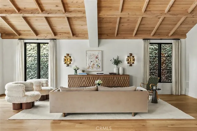 a large white kitchen with cabinets a stove a dining table and chairs with wooden floor