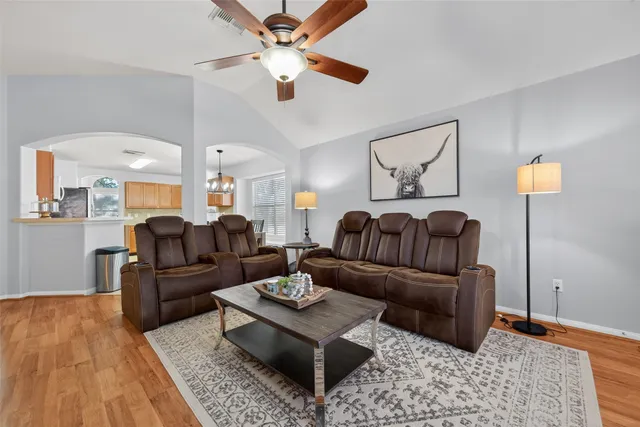 a living room with furniture ceiling fan and a rug