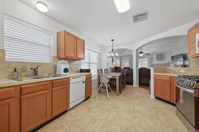 a kitchen with stainless steel appliances granite countertop white cabinets and a stove top oven