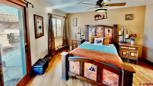 a bedroom with a bed a dresser and windows