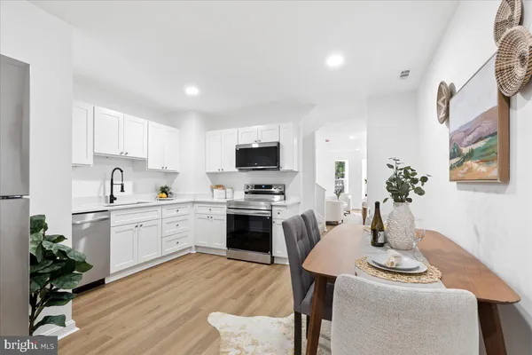 a kitchen with white cabinets stove and kitchen island