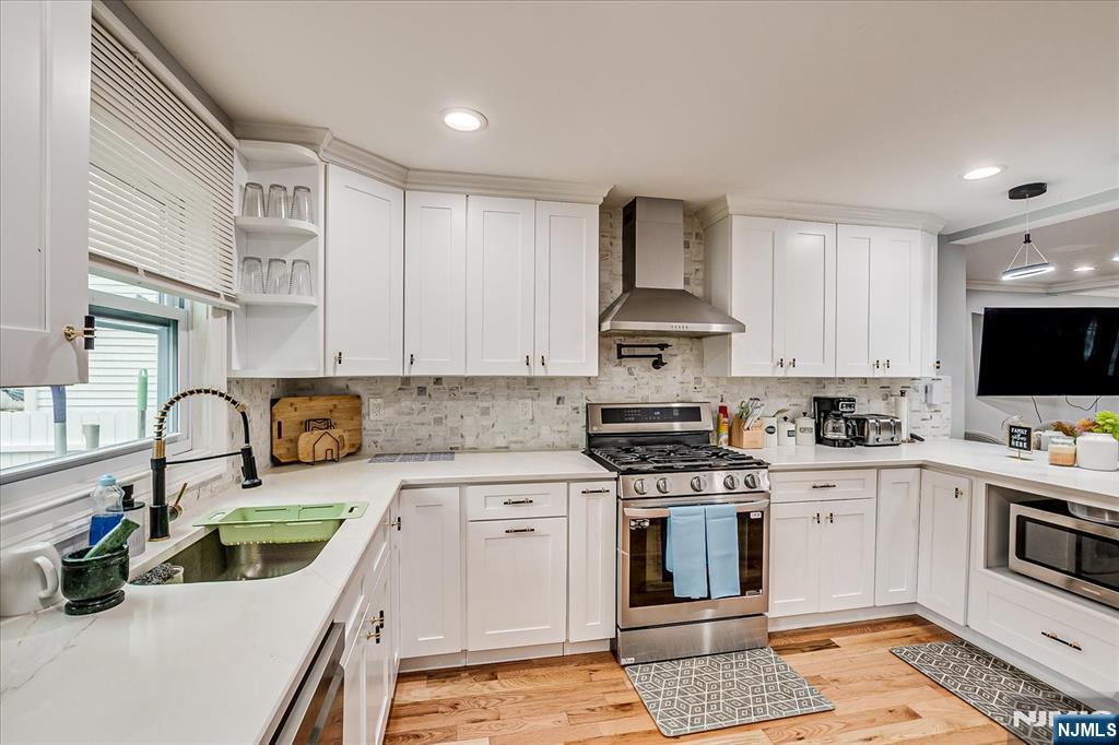 174 Manhattan Avenue Teaneck, NJ 07666 - Photo 12 of 45 a kitchen with stainless steel appliances granite countertop a sink and a stove top oven with white cabinets