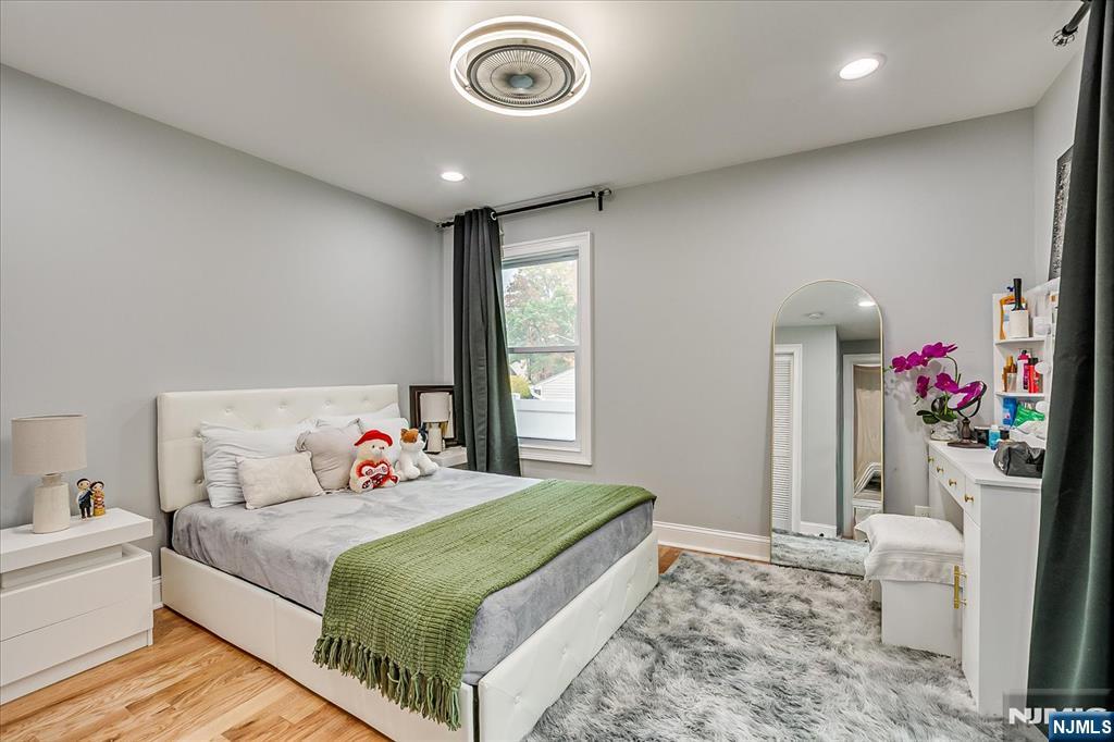 174 Manhattan Avenue Teaneck, NJ 07666 - Photo 14 of 45 a bedroom with a bed and a chandelier