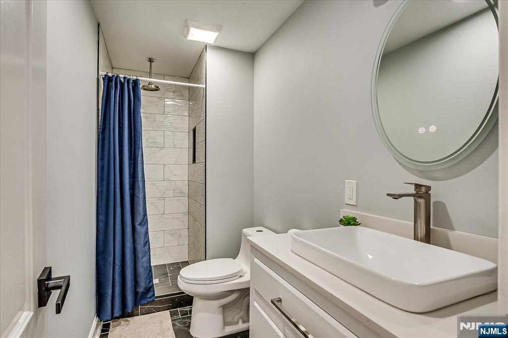 174 Manhattan Avenue Teaneck, NJ 07666 - Photo 16 of 45 a bathroom with a sink a toilet and shower