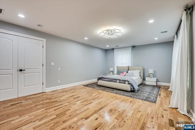 a spacious bedroom with a bed and a chandelier