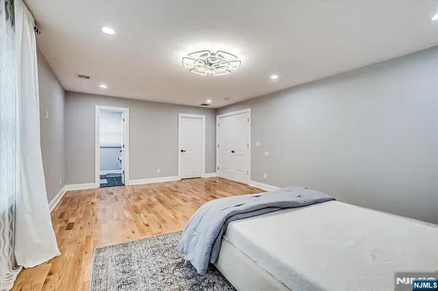 a bedroom with a large bed and a chandelier
