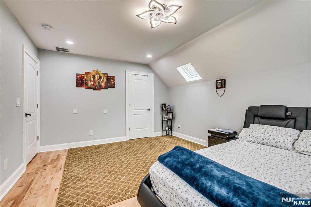 174 Manhattan Avenue Teaneck, NJ 07666 - Photo 24 of 45 a bedroom with a bed and a painting on the wall