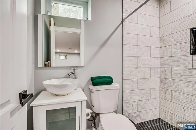 a bathroom with a sink a toilet a mirror and shower