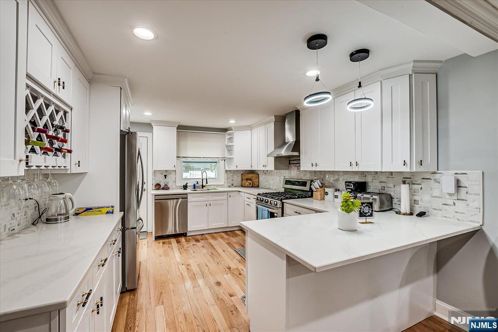 174 Manhattan Avenue Teaneck, NJ 07666 - Photo 10 of 45 a kitchen with a refrigerator a sink and wooden cabinets