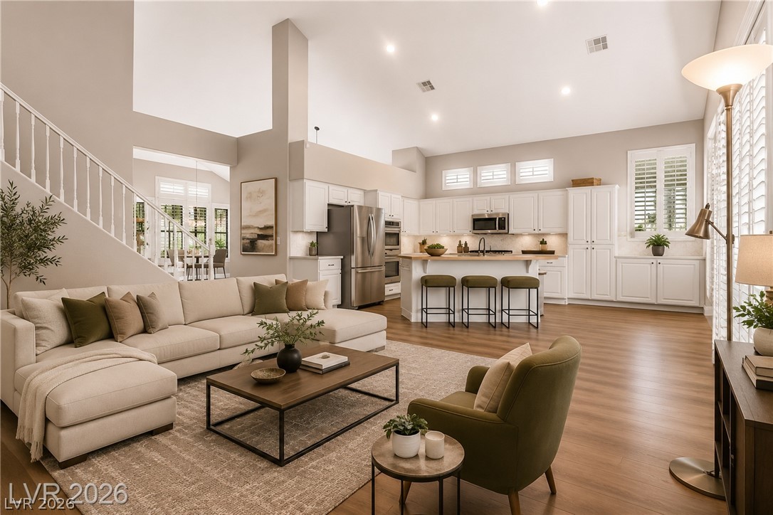 A soaring vaulted ceiling and warm wood flooring define this open-concept main living area.Virtually Staged