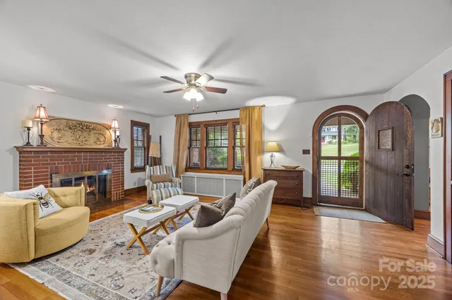 a living room with furniture a fireplace and wooden floor