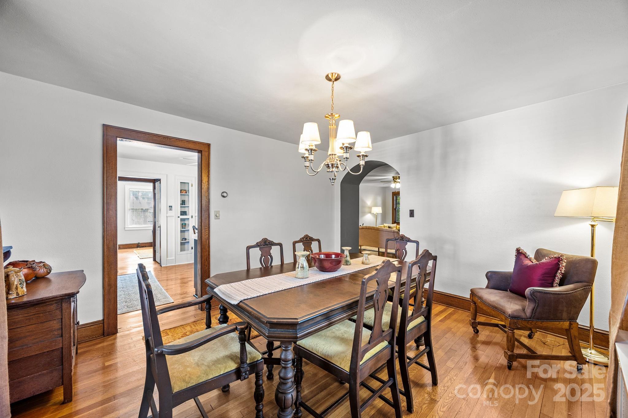 495 Fairview Road Asheville, NC 28803 - Photo 15 of 41 a dining room with furniture potted plants and wooden floor