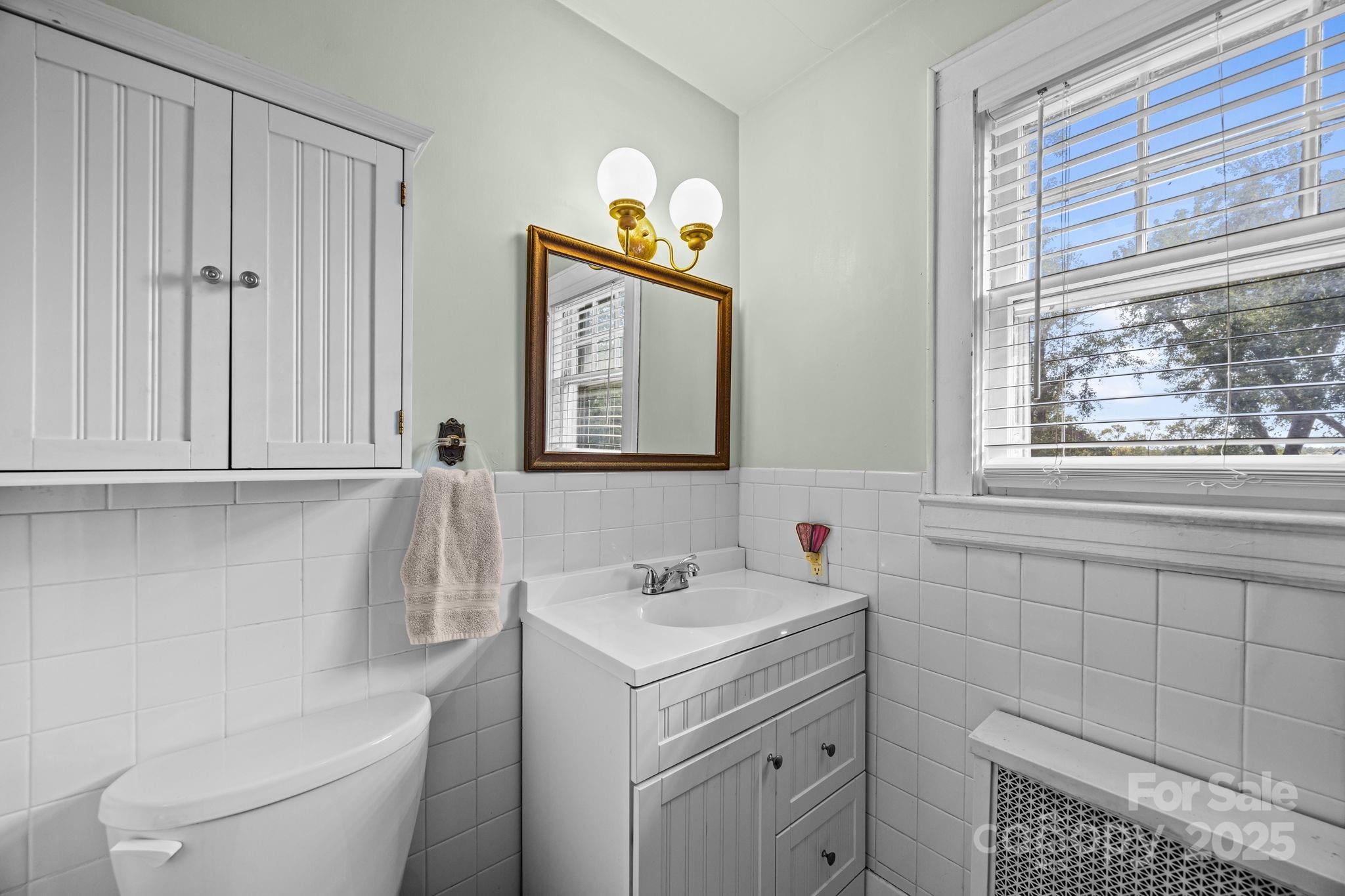 495 Fairview Road Asheville, NC 28803 - Photo 25 of 41 a bathroom with a sink toilet and window