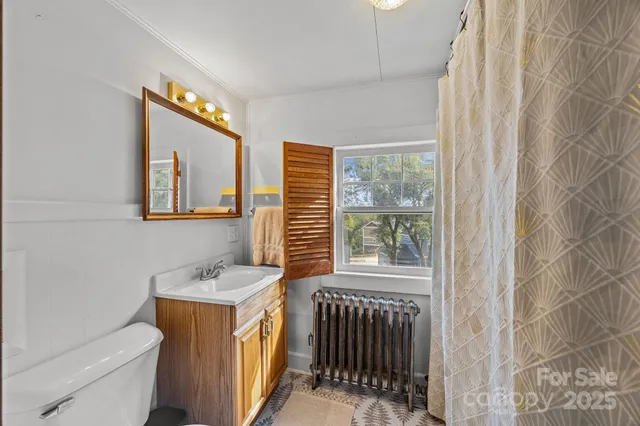 a bathroom with a sink a toilet and a window