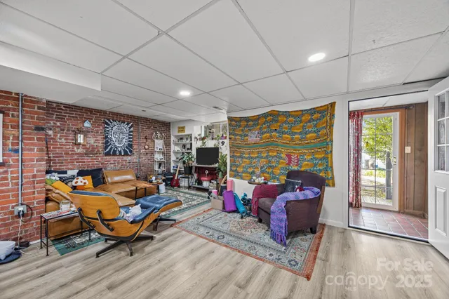 a living room with furniture a rug and a floor to ceiling window