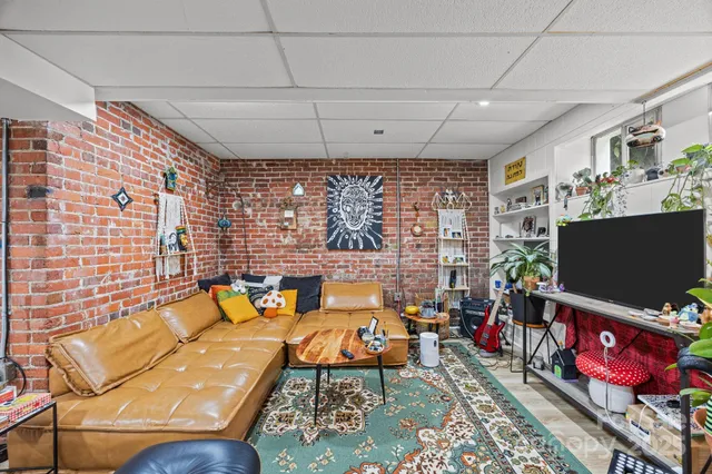 a living room with furniture a flat screen tv and a floor to ceiling window