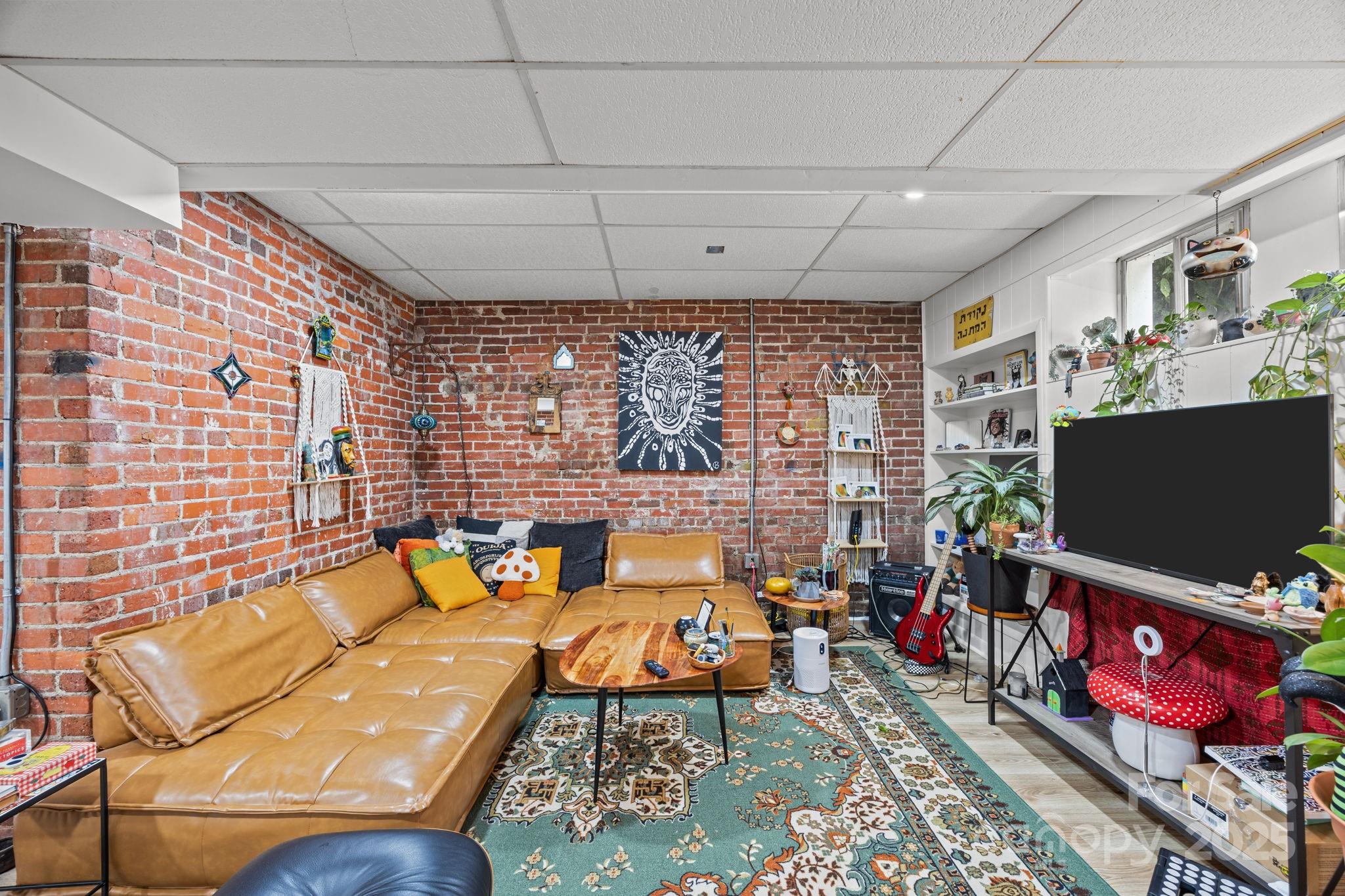 495 Fairview Road Asheville, NC 28803 - Photo 32 of 41 a living room with furniture a flat screen tv and a floor to ceiling window