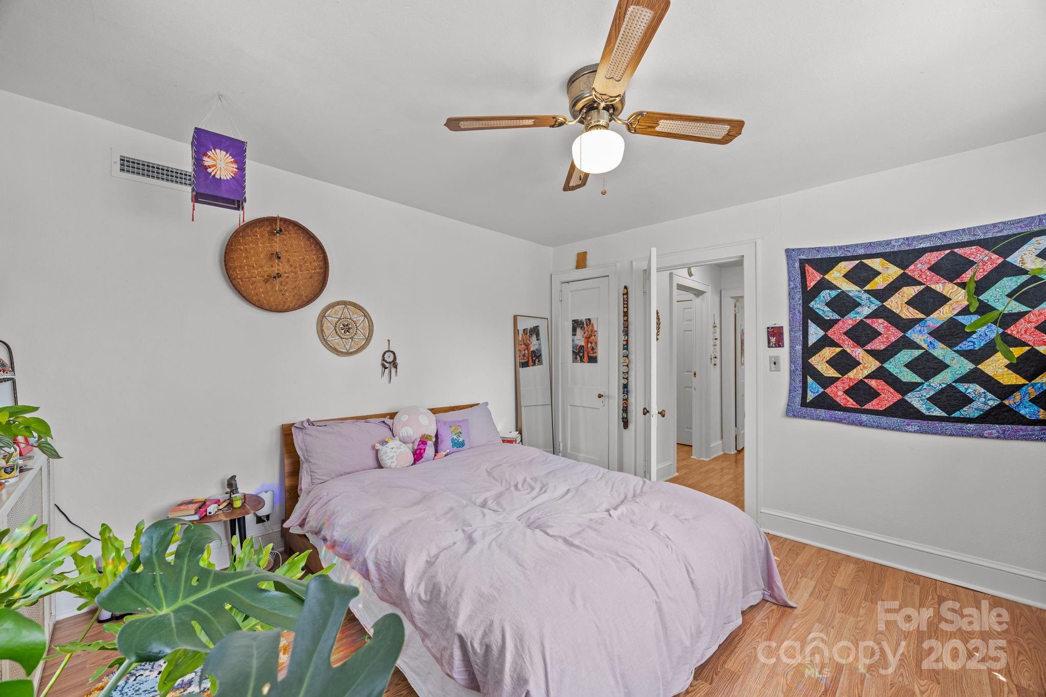 495 Fairview Road Asheville, NC 28803 - Photo 38 of 41 a bedroom with a bed and a chandelier