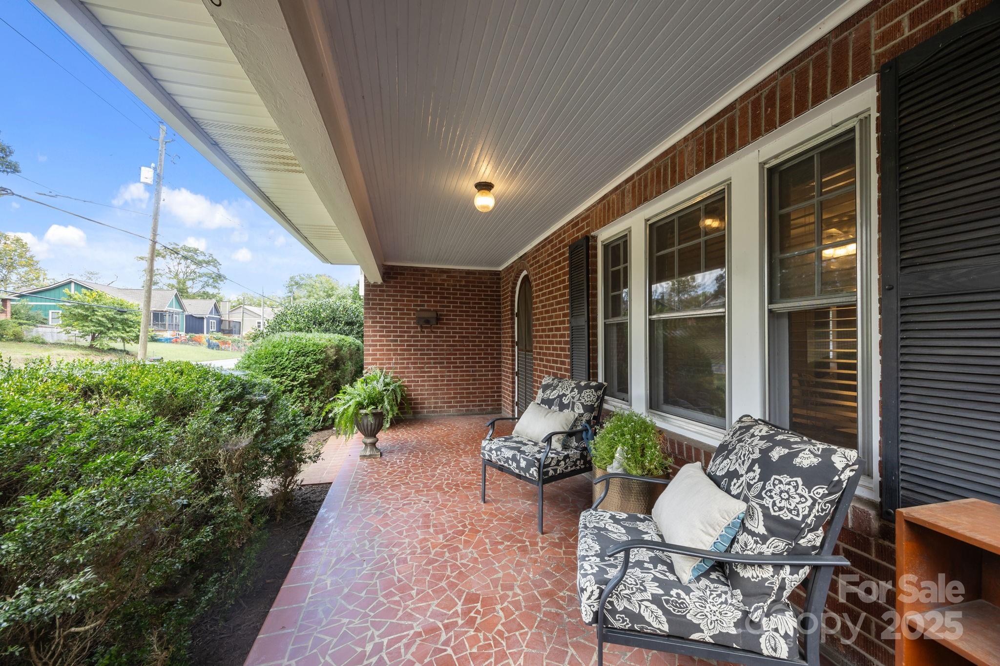 495 Fairview Road Asheville, NC 28803 - Photo 6 of 41 a view of a porch with chairs and a potted plant