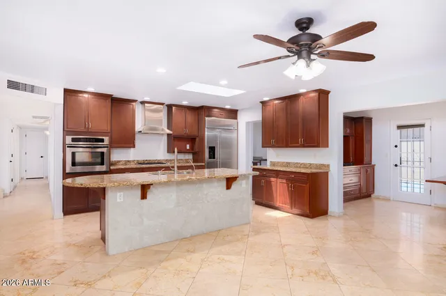 a large kitchen with stainless steel appliances a sink counter space cabinets and a window