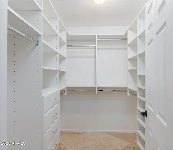 a view of walk in closet with empty racks