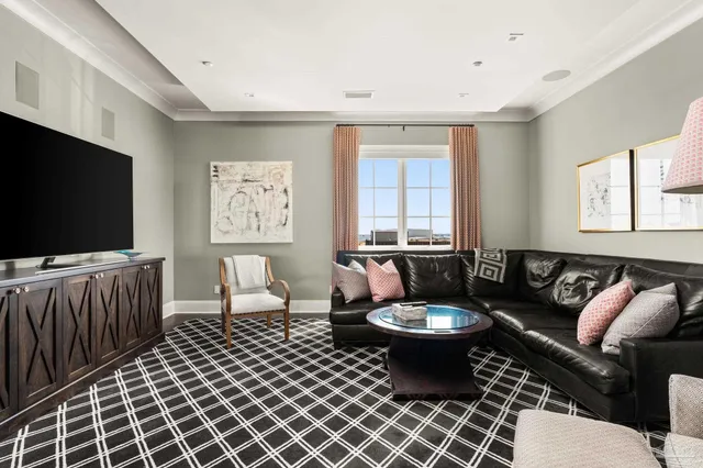 a living room with furniture a flat screen tv and a window