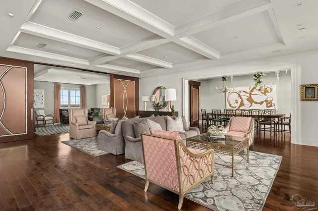 a living room with furniture a wooden floor and a large window